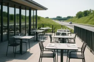 Restaurant med terrasse ved en motorvej i dagslys.