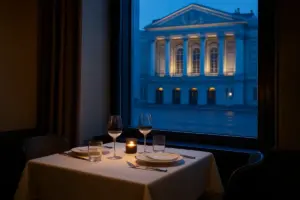 Bord dækket til to ved et vindue med en oplyst teaterfacade på den anden side af gaden.