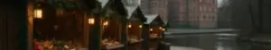 Julemarkedsboder med grangirlander og lanterner i slotsparken ved et renæssanceslot med voldgrav