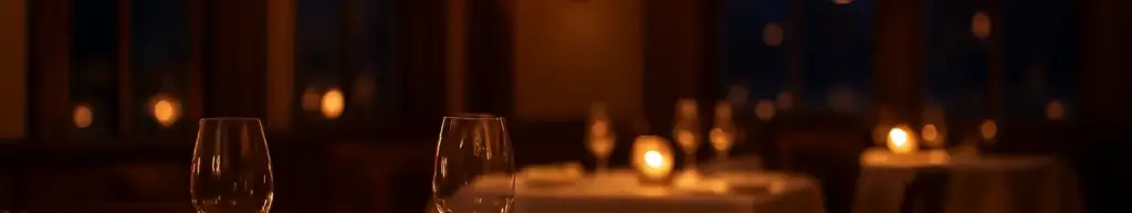 Dækket restaurantbord med små anretninger og vinglas i levende lys en efterårsaften