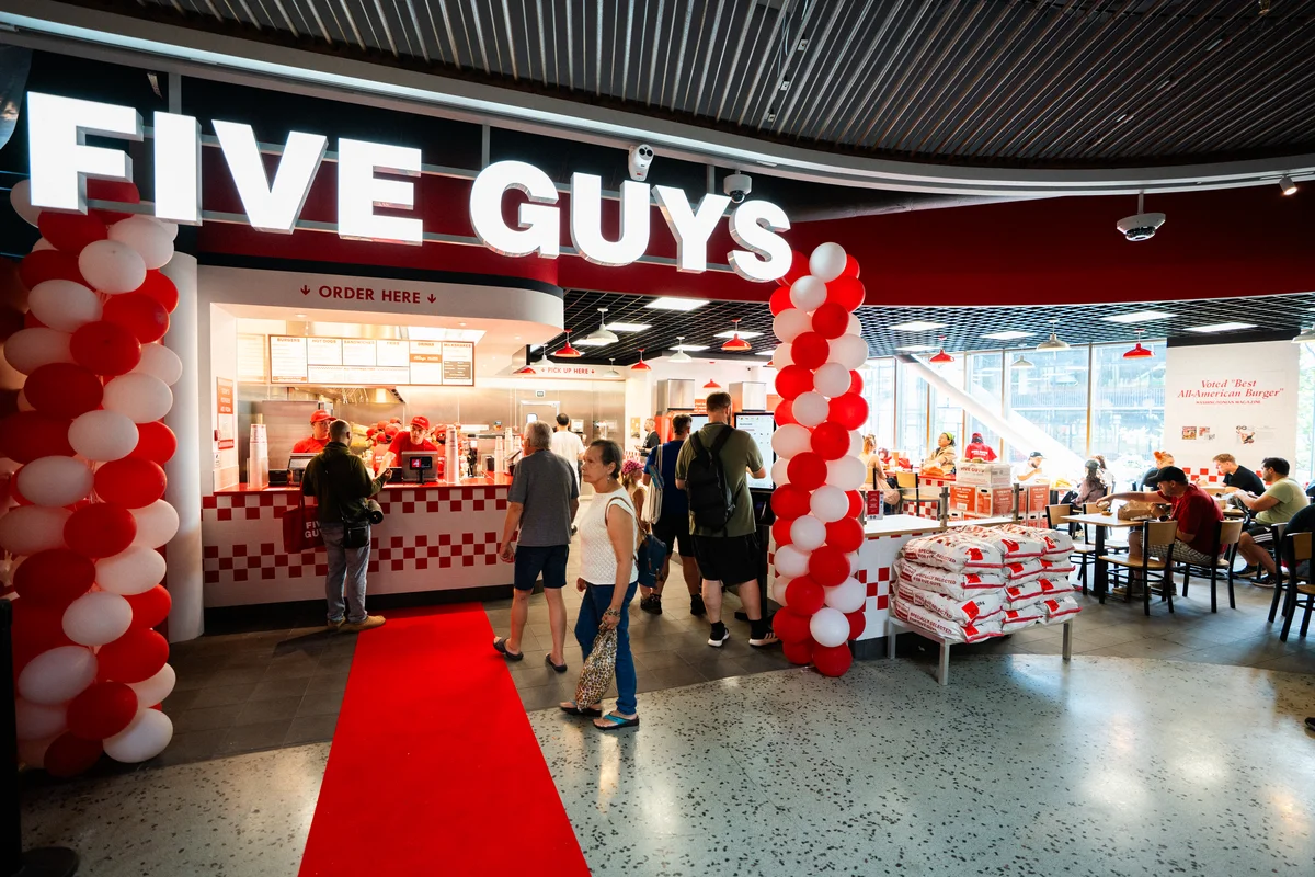 Indgangen til en Five Guys-restaurant i København med røde og hvide balloner